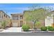 Two-story home featuring a well-manicured lawn, mature tree, and attached two-car garage at 9009 Ochoa St, Las Vegas, NV 89143