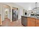 Open kitchen with stainless steel appliances and wood flooring extending to a living area at 9009 Ochoa St, Las Vegas, NV 89143