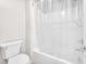 Bright bathroom showing a toilet and tiled tub and shower enclosed with shower curtain at 9198 Rolling Sky Dr, Las Vegas, NV 89178