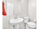 Clean, well-lit half bathroom with a white pedestal sink and a red decorative towel at 9198 Rolling Sky Dr, Las Vegas, NV 89178