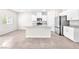 Modern kitchen featuring white cabinets, stainless steel appliances, an island with a sink, and neutral tile flooring at 9198 Rolling Sky Dr, Las Vegas, NV 89178