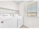 Bright laundry room with a window and updated washer and dryer, and wire shelving at 9198 Rolling Sky Dr, Las Vegas, NV 89178