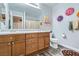 ' bathroom with double sink vanity, wood-look floors, and colorful decorations at 9413 Steeltree St, Las Vegas, NV 89143