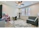Cozy room with ceiling fan, shuttered windows, a gray couch, and laminate flooring with a patterned rug at 9413 Steeltree St, Las Vegas, NV 89143