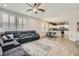 Open-concept living room leads to the kitchen and features a large sectional, ceiling fan, and wood-look floors at 9413 Steeltree St, Las Vegas, NV 89143