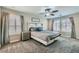 Relaxing primary bedroom with ceiling fan, carpeted floor, shuttered windows and ensuite access at 9413 Steeltree St, Las Vegas, NV 89143