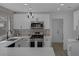 Modern kitchen features white cabinets, quartz countertops, stainless steel appliances and pendant lighting at 9437 January Dr, Las Vegas, NV 89134