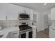 Bright modern kitchen with stainless steel appliances, white cabinets and stylish backsplash at 9437 January Dr, Las Vegas, NV 89134