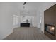 Living room with modern fireplace feature, light wood floors, kitchen view, and plantation shutters at 9437 January Dr, Las Vegas, NV 89134