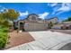 Inviting two-story home featuring a three-car garage, well-manicured landscaping, and a charming exterior at 955 Leadville Meadows Dr, Henderson, NV 89052
