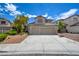 Beautifully landscaped two-story home with a spacious driveway, three-car garage, and well-maintained lawn at 955 Leadville Meadows Dr, Henderson, NV 89052