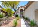 Charming home entrance with arched doorway, manicured landscaping, and a welcoming pathway at 955 Leadville Meadows Dr, Henderson, NV 89052