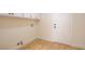 Clean laundry room with wood-look flooring and white cabinets, perfect for organization at 955 Leadville Meadows Dr, Henderson, NV 89052