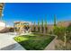 Green backyard featuring a pergola with seating and tall, slender trees bordering the space at 9953 Fletcher Peak Ave, Las Vegas, NV 89178
