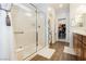 Clean bathroom featuring glass shower, wood look tile and access to the walk-in closet at 9953 Fletcher Peak Ave, Las Vegas, NV 89178