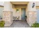 Inviting porch with stone columns, a cozy seating area, and a stylish front door creating a welcoming entrance to the home at 9953 Fletcher Peak Ave, Las Vegas, NV 89178