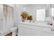 Clean, bright bathroom features a floral shower curtain, a large mirror, and a white vanity at , North Las Vegas, NV 89031