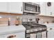 Close up of kitchen with stainless steel oven, microwave, quartz countertops, and white cabinets at , North Las Vegas, NV 89031