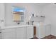 Bright laundry room with white cabinets, countertop space, shelving, and washer/dryer at , North Las Vegas, NV 89031