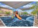 Community playground featuring colorful play structures, a slide, and shade canopies on a rubberized surface at , North Las Vegas, NV 89031