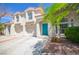 Charming two-story home boasts a striking turquoise door and a well-maintained, landscaped front yard at 1000 Grammy Dr, Las Vegas, NV 89145