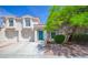 Charming two-story home boasts a striking turquoise door and a well-maintained, landscaped front yard at 1000 Grammy Dr, Las Vegas, NV 89145
