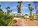 Welcoming entrance to Stone Canyon Northwest, surrounded by lush palm trees and desert landscaping at 1000 Grammy Dr, Las Vegas, NV 89145