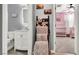 A half bathroom attached to a room decorated with throws, looking into a pink room at 1024 Fishing St, Henderson, NV 89011