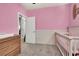 Charming bedroom with pink walls, a white crib, and a wooden dresser at 1024 Fishing St, Henderson, NV 89011
