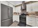Modern kitchen featuring stainless steel appliances, white cabinets, and a stylish tile backsplash at 1024 Fishing St, Henderson, NV 89011