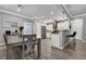 Open-concept kitchen featuring modern lighting, stainless steel appliances, and stylish dining area at 1024 Fishing St, Henderson, NV 89011
