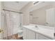 Bright bathroom with a large mirror, white cabinetry, and a shower-tub combination at 10324 Lettuce Leaf St, Las Vegas, NV 89183