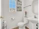 Clean, white bathroom with a pedestal sink, toilet, and decorative accents at 10324 Lettuce Leaf St, Las Vegas, NV 89183