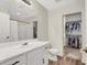 Bathroom featuring white cabinets, a large mirror, and a walk-in closet offers practical storage at 10324 Lettuce Leaf St, Las Vegas, NV 89183