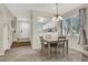 Bright dining area with wood-style flooring, large window, and a partial view of the kitchen at 10324 Lettuce Leaf St, Las Vegas, NV 89183