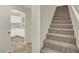 View of carpeted staircase with a glimpse into the kitchen, featuring modern white cabinetry at 10324 Lettuce Leaf St, Las Vegas, NV 89183