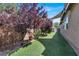 Lush backyard features artificial grass and mature trees, creating a private outdoor oasis at 10385 Kern Ridge St, Las Vegas, NV 89178