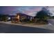 Charming single-story home featuring a well-manicured front yard, desert landscaping, and an attached two-car garage at dusk at 10385 Kern Ridge St, Las Vegas, NV 89178