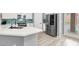 Modern kitchen with stainless steel appliances and an island with a large sink and white countertops at 10385 Kern Ridge St, Las Vegas, NV 89178