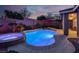 Inviting pool and spa illuminated at night with a stylish red umbrella, creating a serene backyard retreat at 10385 Kern Ridge St, Las Vegas, NV 89178