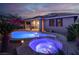 Stunning backyard at twilight features a pool and spa, illuminated for a magical ambiance at 10385 Kern Ridge St, Las Vegas, NV 89178