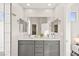 Bright bathroom featuring a large mirror above the gray vanity with double sinks and tiled walls at 1357 Manassas Rdg Rdg, Mesquite, NV 89027