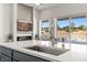 Kitchen island with a sink overlooking a living space, fireplace, and backyard pool at 1357 Manassas Rdg Rdg, Mesquite, NV 89027
