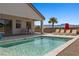 Inviting backyard pool area with lounge chairs, an umbrella, covered patio, and desert landscaping at 1357 Manassas Rdg Rdg, Mesquite, NV 89027