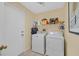 Bright laundry room featuring a washer, dryer, and shelving for organized storage space at 1991 High Mesa Dr, Henderson, NV 89012