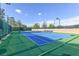 This is a well-maintained, blue outdoor tennis court surrounded by lush landscaping, and tall fences for enjoyable games at 1991 High Mesa Dr, Henderson, NV 89012