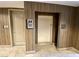 Wood-paneled hallway featuring a well-maintained elevator with nearby stairwell and trash disposal at 20 E Serene Ave # 111, Las Vegas, NV 89123