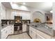 This renovated kitchen features white cabinets, granite counters and backsplash, and stainless appliances at 20 E Serene Ave # 111, Las Vegas, NV 89123