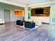 Inviting lobby area with modern seating, wood-look flooring, and an accent wall with a mounted TV at 20 E Serene Ave # 111, Las Vegas, NV 89123