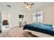 Comfortable bedroom with a TV, a ceiling fan, carpet floors, and an open doorway to the sitting area at 2110 Albury Ave, North Las Vegas, NV 89086